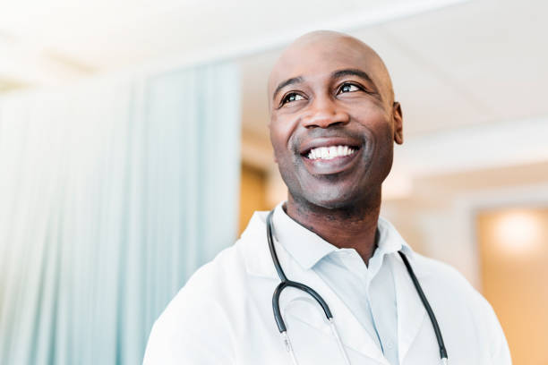 close-up of happy confident doctor looking away - happy doctor imagens e fotografias de stock