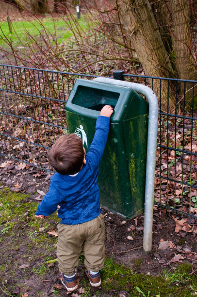 istock Toddler Throwing Away Trash in Public Park 904793996