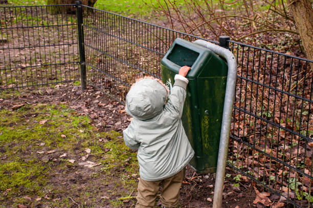 istock Small Child Throwing Away Trash in Public Park 904794000