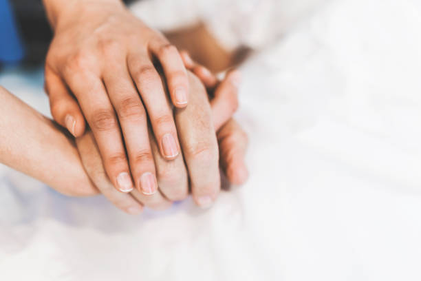 immagine ritagliata dell'infermiera che tiene la mano dell'uomo - holding hands human hand senior adult consoling foto e immagini stock