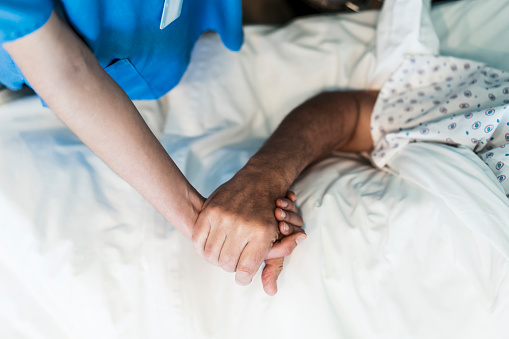 Cropped image of nurse holding patient's hand. Close-up of healthcare worker consoling patient. They are in hospital.