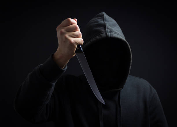istock A killer with a knife in his hand in the dark 904794520