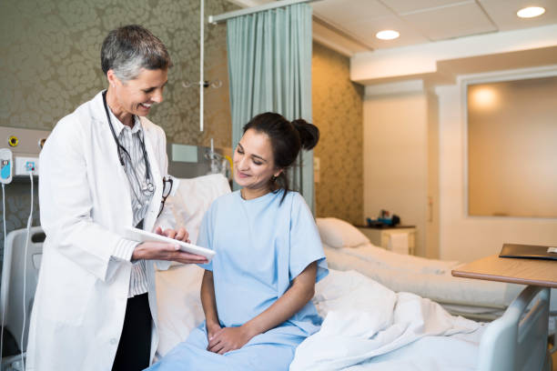 istock Smiling doctor showing digital tablet to patient 904794982