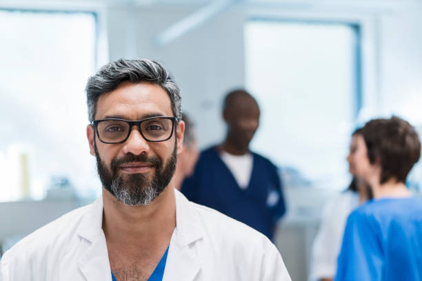 istock Smiling male doctor against colleagues 904805318