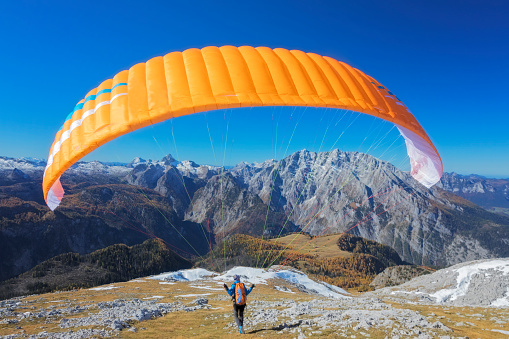 Paraglider just starting in Nationalpark Berchtesgaden over Lake Königssee with view to Mount Watzmann