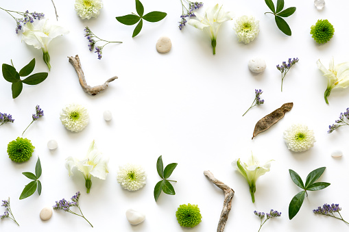 Frame with white, green and purple flowers on white background. Wedding background.