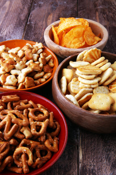 istock Salty snacks. Pretzels, chips, crackers in wooden bowls. 904817448