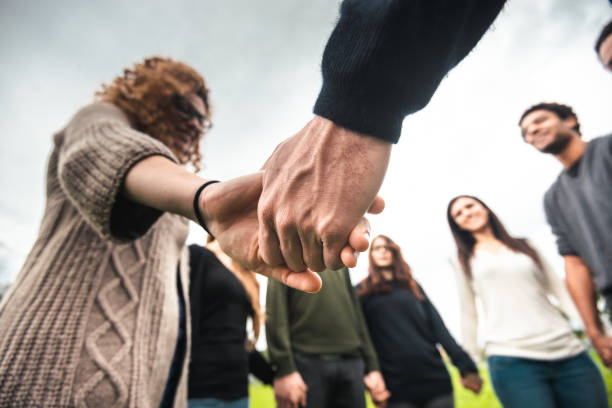 concept de diversité - main dans la main - holding hands human hand holding multi ethnic group photos et images de collection