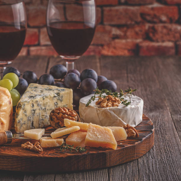 istock Cheese, nuts, grapes and red wine on wooden background 904821476