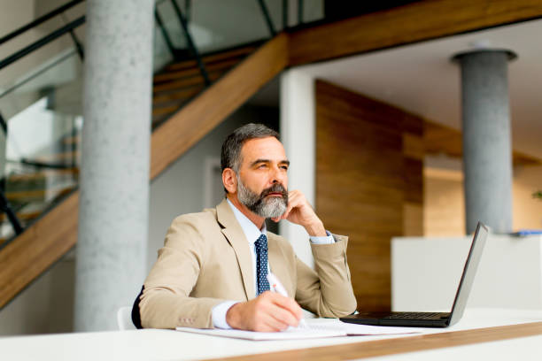 istock Senior businessman working on laptop computer in office 904827108