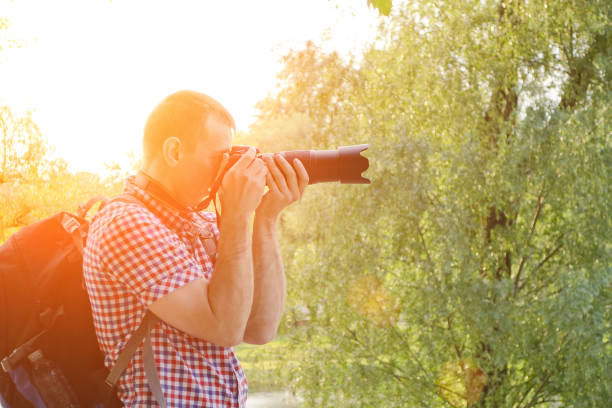 istock Photographer with SLR camera and backpack in nature, side view 904829624