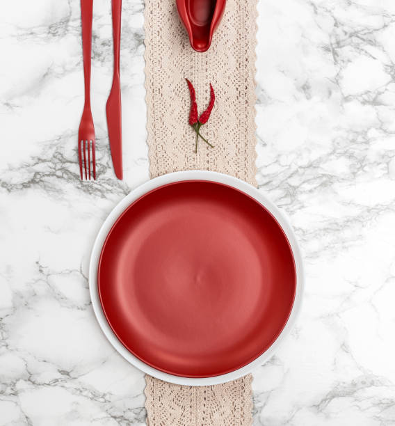 istock Red dishes and cutlery on the marble table. 904834104