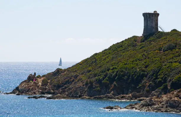 Corsica, France, Europe - September 4, 2017: the Mediterranean Sea and the Genoese Tower on the Pinarello beach, one of the most famous beaches of the southern coast, in the locality of Sainte Lucie de Porto Vecchio