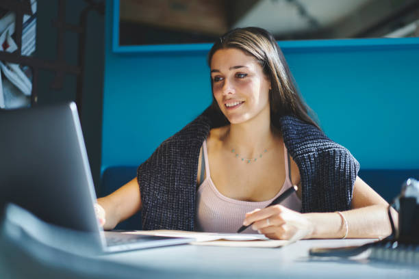 istock Smiling attractive brunette copywriter reading news on website sharing multimedia content using laptop computer and wireless internet, charming hipster girl working on freelance earning money online 904839946
