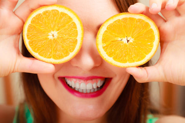 istock Woman covering eyes with orange. 904841190