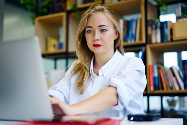 concentrate female student watching training webinar on laptop computer improving knowledge and skills preparing for examination, business woman making researches planning startup browsing information - training computer learning computer lab imagens e fotografias de stock