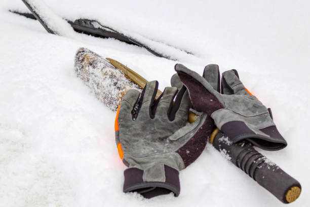 стокові фото, фото роялті-фрі та зображення на тему снігова щітка і зимові рукавички на засніженому капоті автомобіля крупним планом - winter safety work gloves