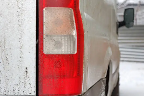 Photo of Dirty track tail light closeup. Car in winter