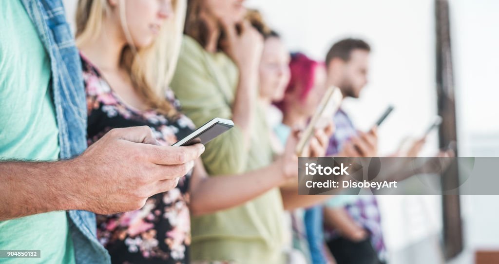 Group of students friends using smartphones outdoor - Young people having fun with technology trends - Youth and friendship concept - Focus on left man hand mobile phone Smart Phone Stock Photo