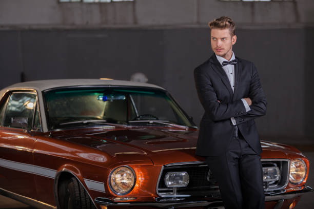 Young handsome man with classic car in garage