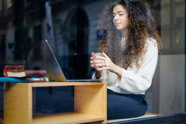istock Charming young female student enjoying watching movie using laptop computer and wifi connection in cafe interior, beautiful freelancer resting news from internet while resting on coffee break 904866994