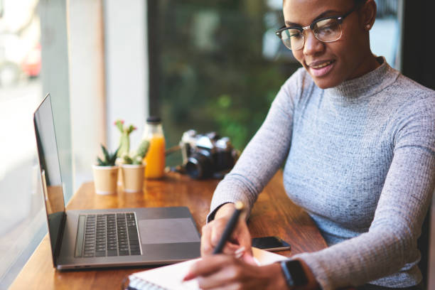 istock Smiling attractive afro american designer creating sketch planning project while spending time in coffee shop, skilled freelancer making marketing research enjoying working process in cafe interior 904867746