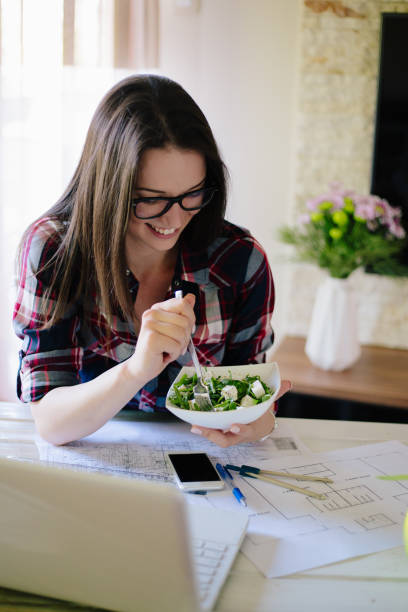 istock Young woman working from home and having healthy meal 904879536