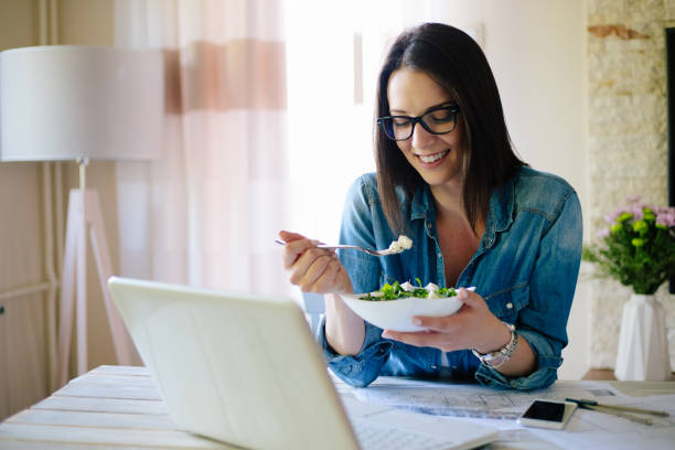 istock Young woman working from home and having healthy meal 904879782