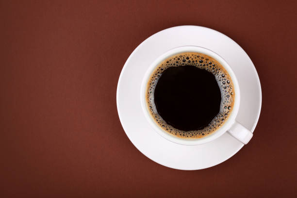 istock Full cup of black coffee in white cup on brown 904879938