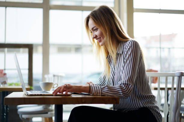 istock Smiling blonde female marketing expert developing advertising campaign for web store earning money online working on freelance, cheerful student watching video on laptop computer connected to wifi 904880038