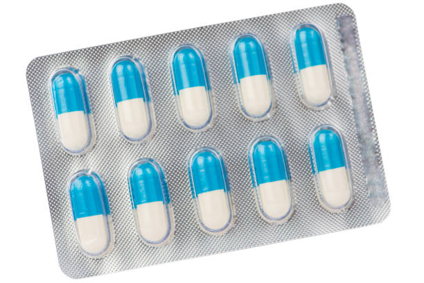 istock Blue and white capsule in transparent blister pack on white 904881332