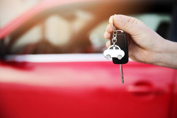 hand holding keys to new car - chave de carro imagens e fotografias de stock