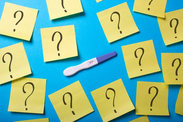 How to know the gender of the child. Why do I get pregnant? Contraceptives do not work. Positive pregnancy test with two strips and office stickers with a question mark.