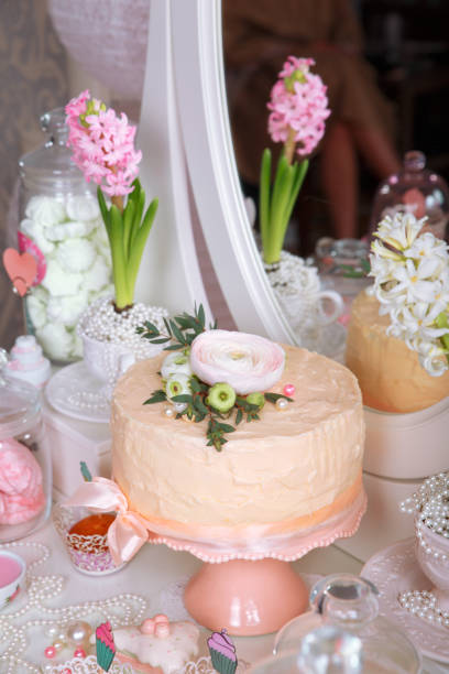 istock Dessert Table at Wedding Reception. Beautiful wedding cake with flowers on table 904890374