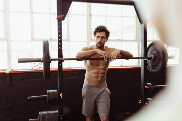 homem, inclinando-se sobre a barra, após o treinamento - crouching barbell weightlifting weight training - fotografias e filmes do acervo