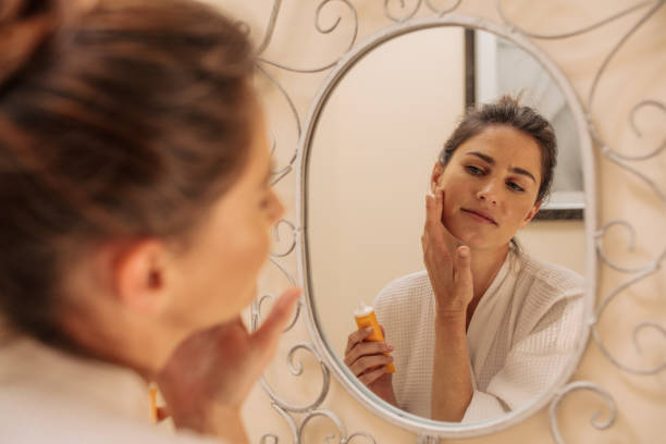 istock Female applying cream onto her face 904892440