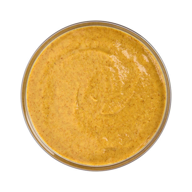 istock Mustard in glass bowl isolated on white background. Top view 904892586
