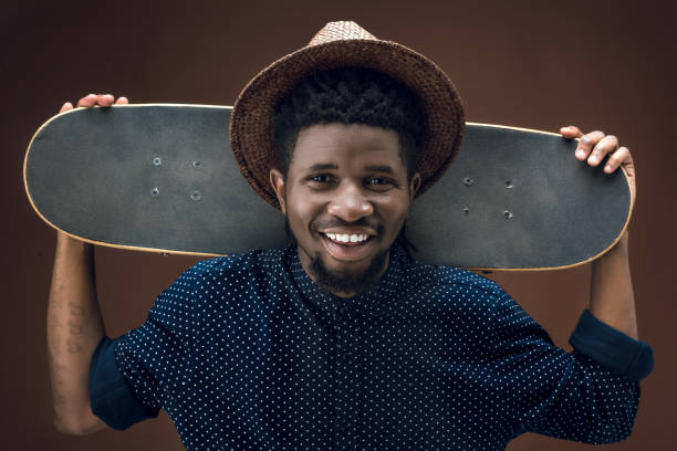 istock smiling african american man with skate isolated on brown 904899086
