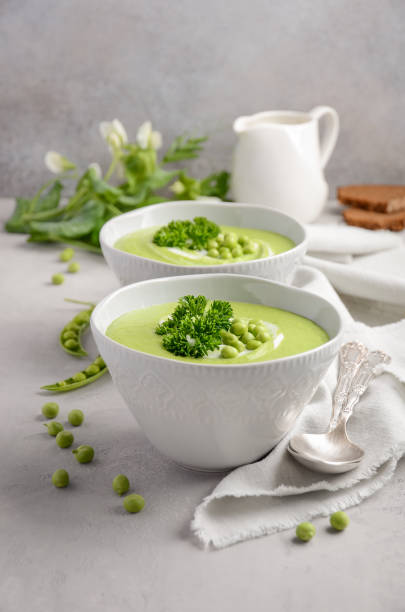 istock Green pea soup in bowls on grey concrete or stone background 904899158
