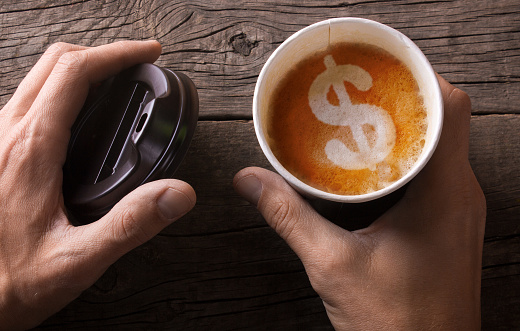 Expensive black coffee take-out. Business for sale of coffee. The man is holding a mug of coffee with foam in the form of a dollar sign.