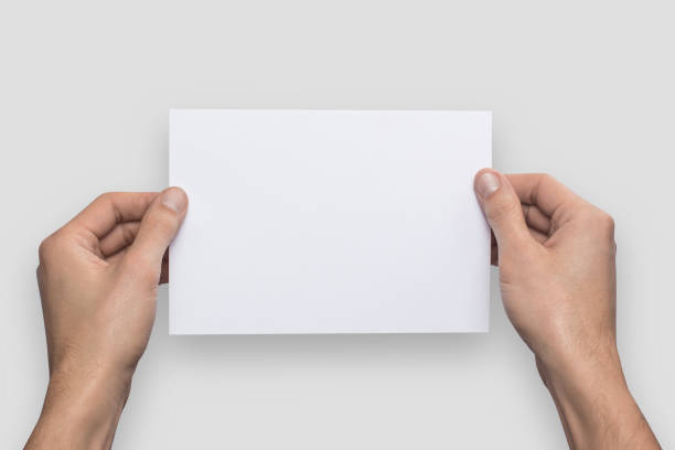 istock Mockup A5 letter horizontally empty blank white holds the man in his hand. Isolated on a gray background 904905828