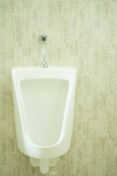 istock Modern white ceramic urinals in men's bathroom on tiles background 904905936