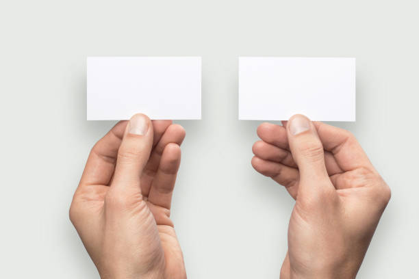 istock Mockup business card back and front horizontal empty blank holds the man in his hand. Isolated on a gray background 904906006