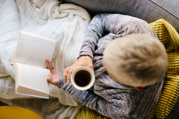 istock Woman reading book and drinking coffee 904906428