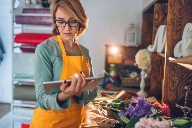 istock Young florist using digital tablet in flower shop 904909810