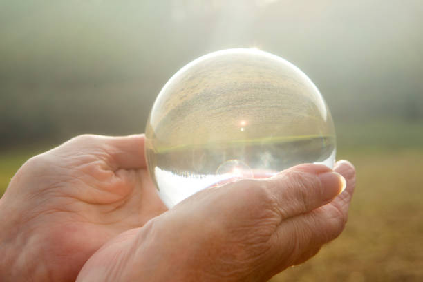 istock older womans hand holding a shiny glass sphere 904909974