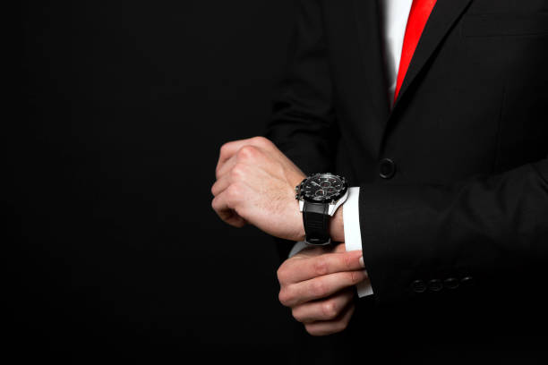 istock Confident businessman adjusting cuff and looking at wrist watch 904915216