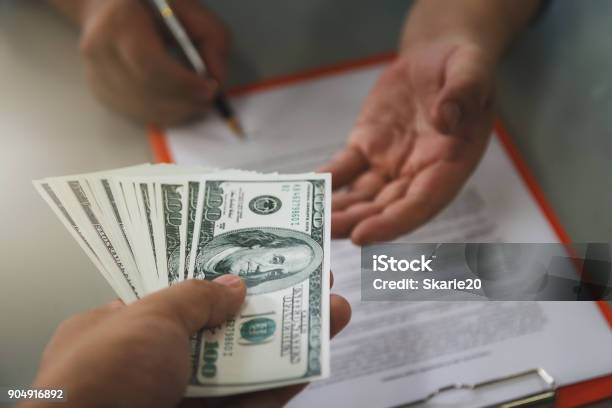 Man Offering Batch Of Hundred Dollar Bills Close Up Of Business Man Signing Contract Making A Deal Business Contract Details Stock Photo - Download Image Now