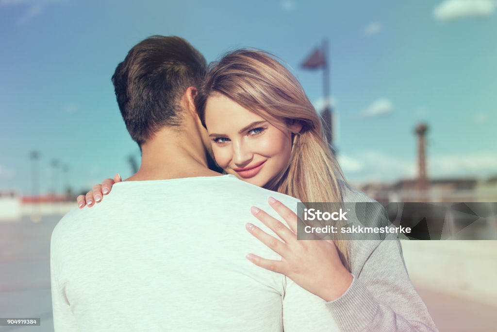 Young woman embracing casual man and smile Young woman embracing casual man and smile, love, outdoors Women Stock Photo