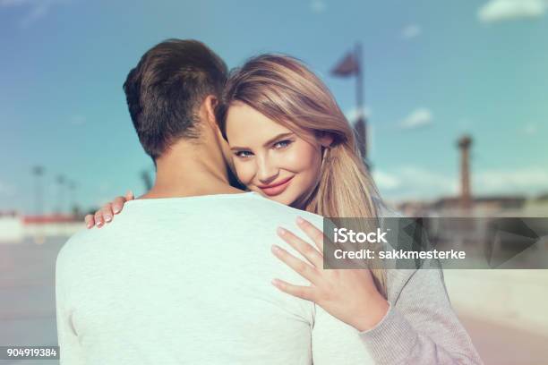 Young Woman Embracing Casual Man And Smile Stock Photo - Download Image Now - Women, Young Couple, Dating